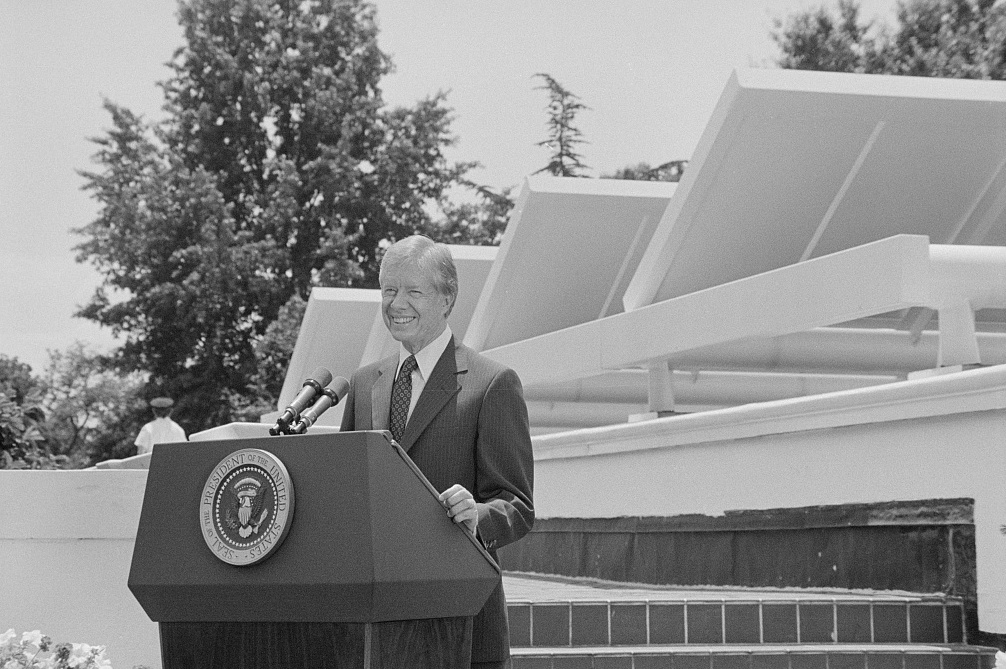 President Jimmy Carter speaking in front of solar panels placed on the West Wing roof of the White House, announcing his solar energy policy