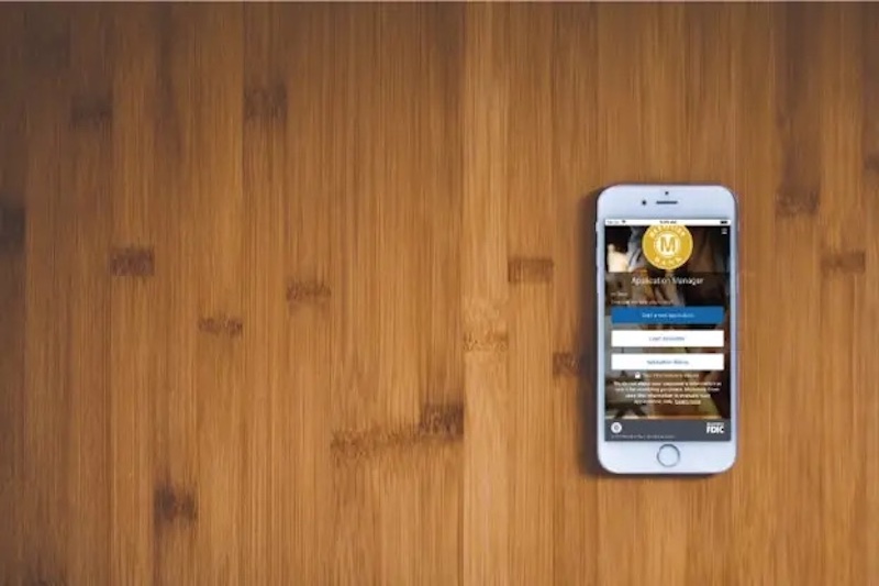 A rendering of a phone with the medallion bank app open on a wooden background