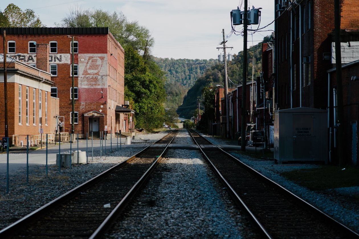 A photo of a town with old brick buildings and train tracks running right through town