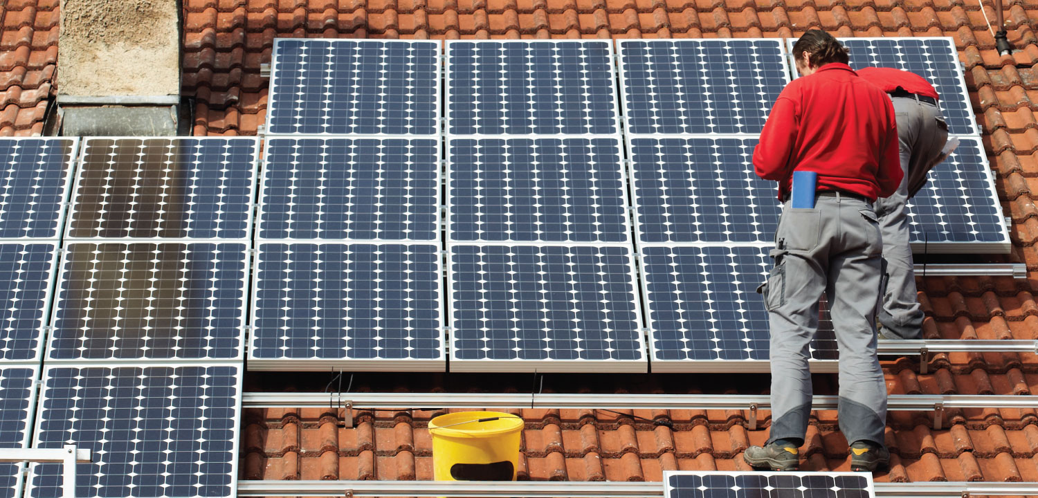 Two solar installers working on a roof